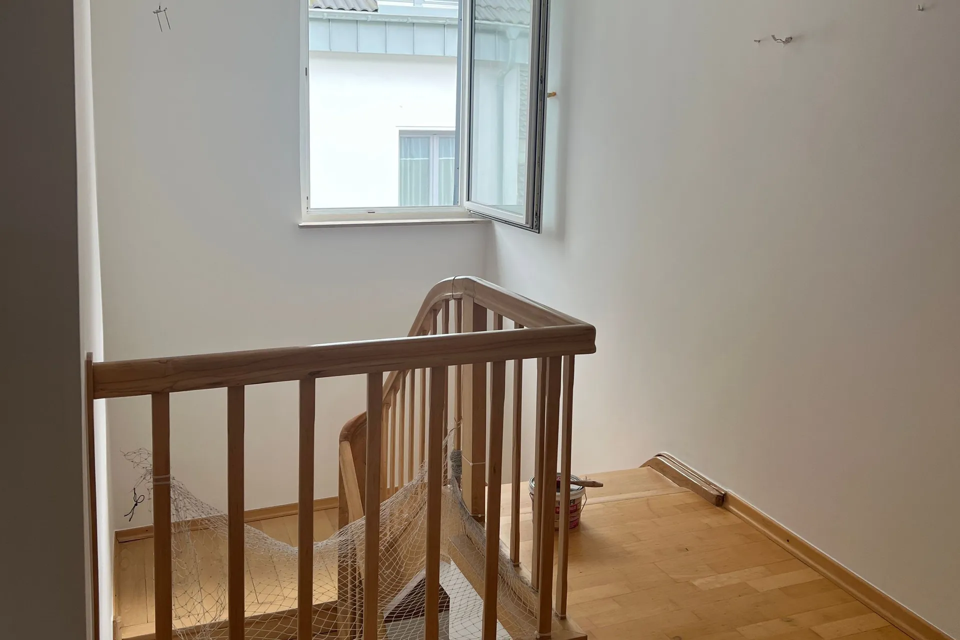 Frisch saniertes Treppenhaus mit glatten weißen Wänden und neuem Holzboden